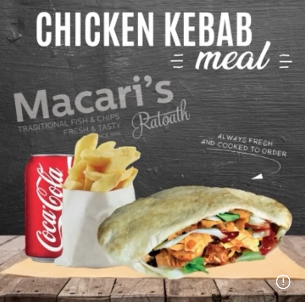 Chicken kebab meal with chips and a can of Coca-Cola, served on a wooden table with a dark chalkboard-style background.
