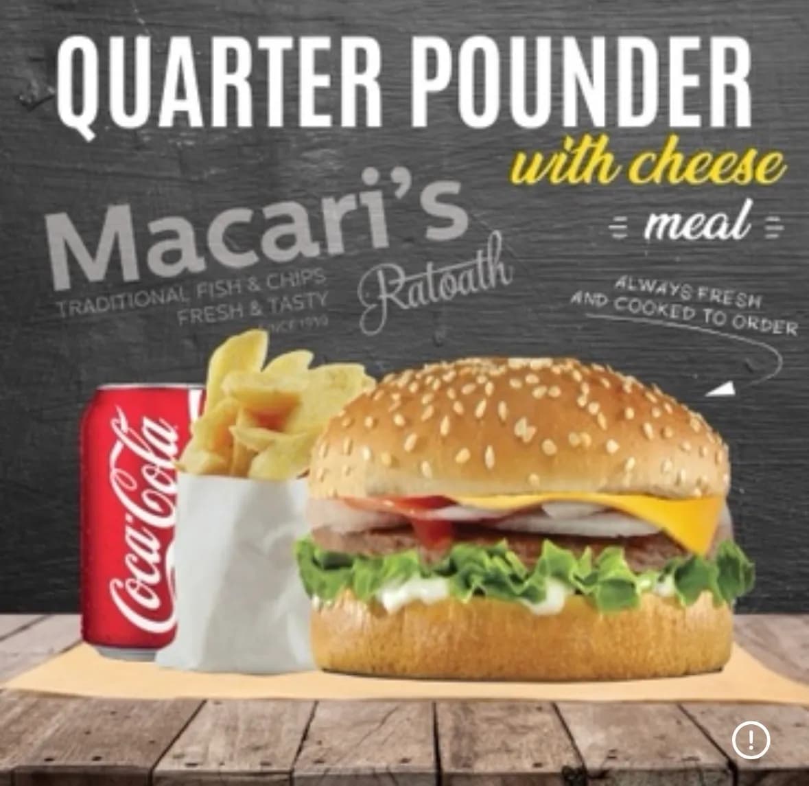 Quarter pounder cheeseburger meal with chips and a can of Coca-Cola, served on a wooden table with a dark chalkboard-style background.